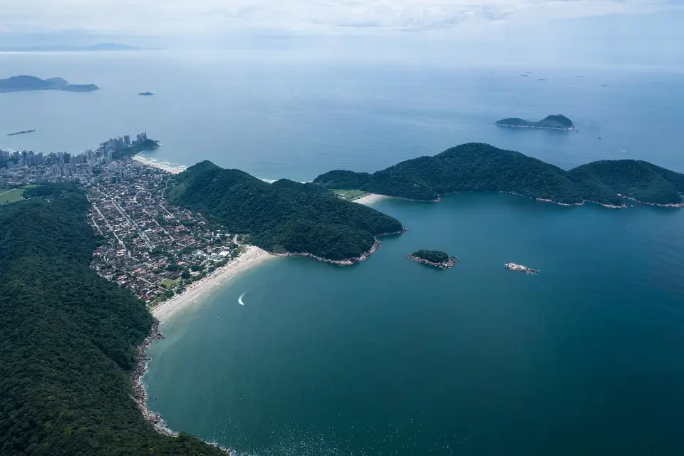 Vista aérea das praias do Tombo e da Guaiúba, no Guarujá, entre morros cobertos de mata