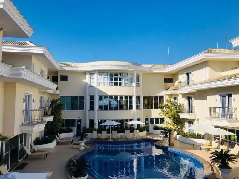 Pátio da piscina do Hotel Doral Guarujá com espreguiçadeiras e guarda-sóis