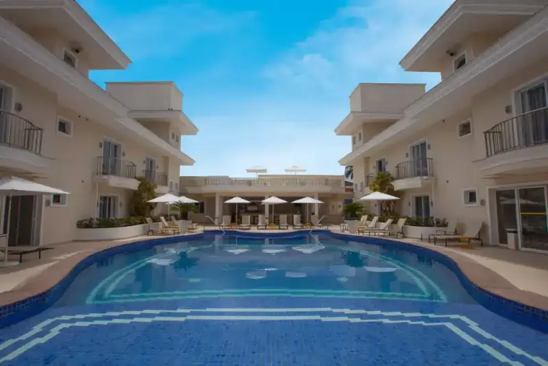 Piscina do Hotel Doral Guarujá sob céu azul, na Praia da Enseada